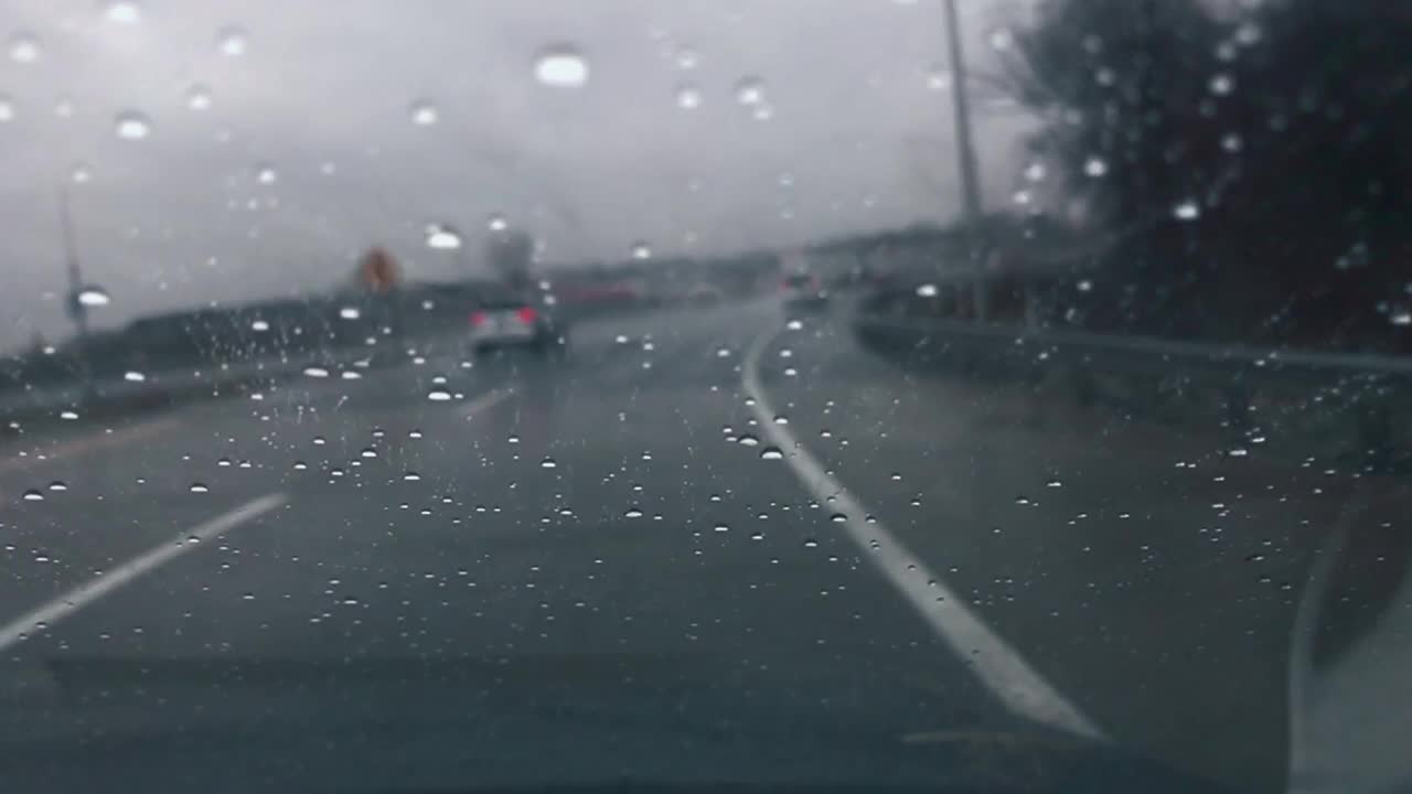 在雨中开车，雨滴在挡风玻璃上移动视频素材