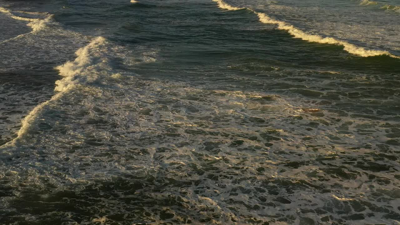 空中视频飞行在水面附近的海岸Praia do Guincho海滩在卡斯凯斯，葡萄牙，在日出视频素材