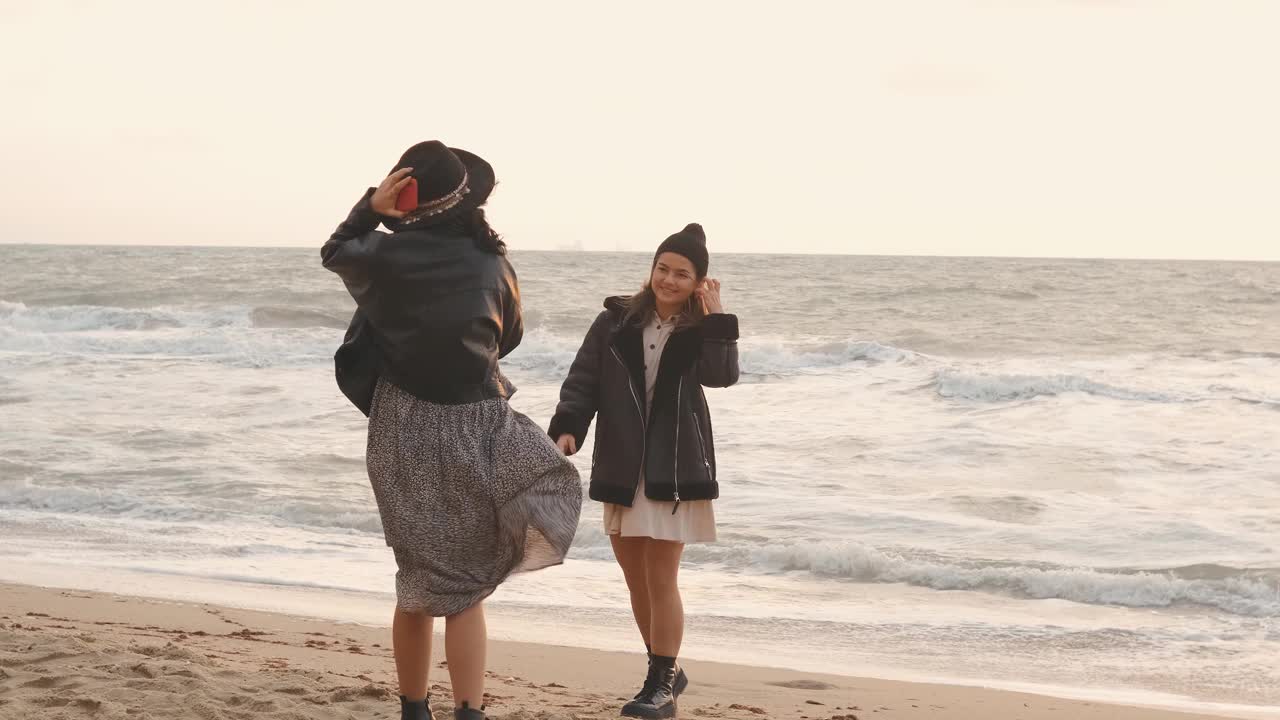 日落时分，一对美丽的年轻女子在海滩上漫步视频素材