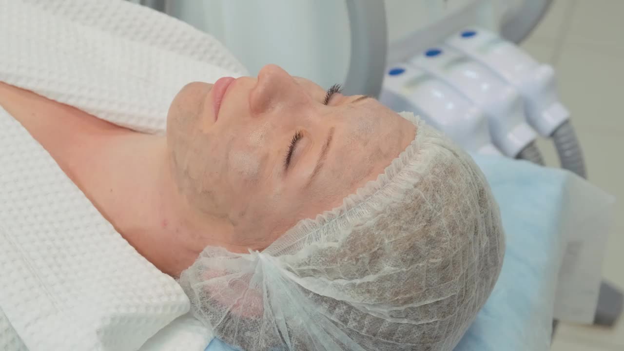 Cosmetological过程。在美容院进行碳脱皮手术之前，这个女人闭上了顾客的眼睛视频下载