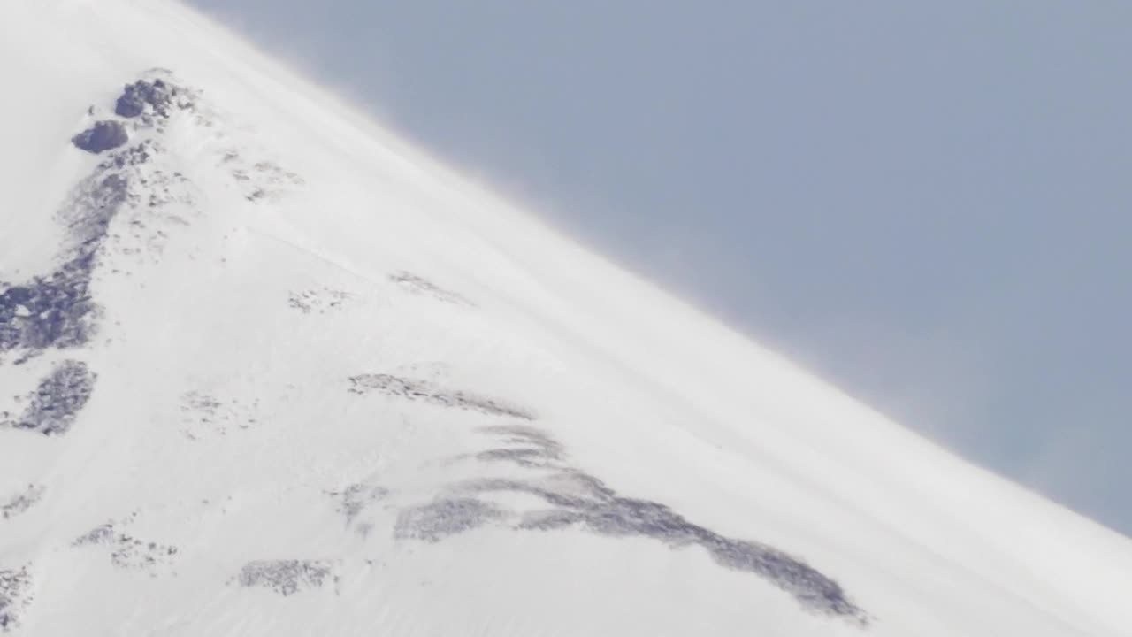 大雪在山顶的斜坡上飘过视频素材