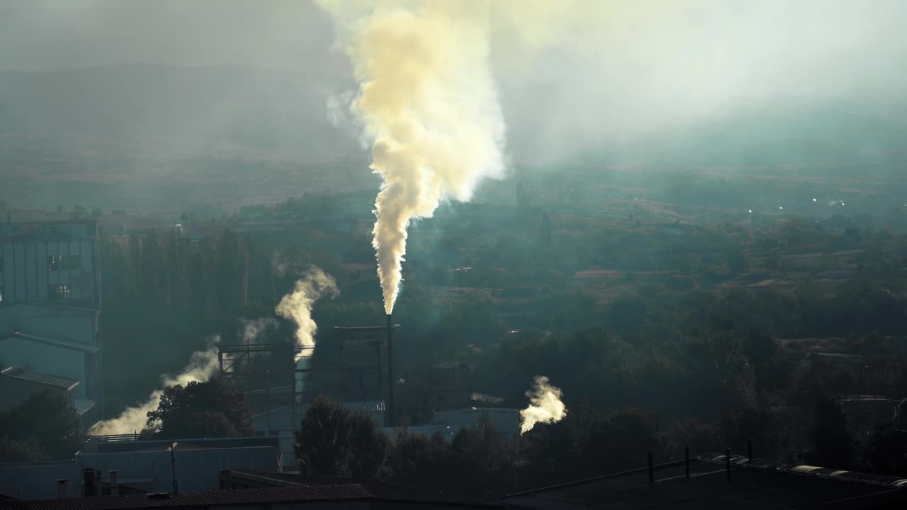 工业景观的空气污染，工厂的管道在日出时排放有毒烟雾视频素材