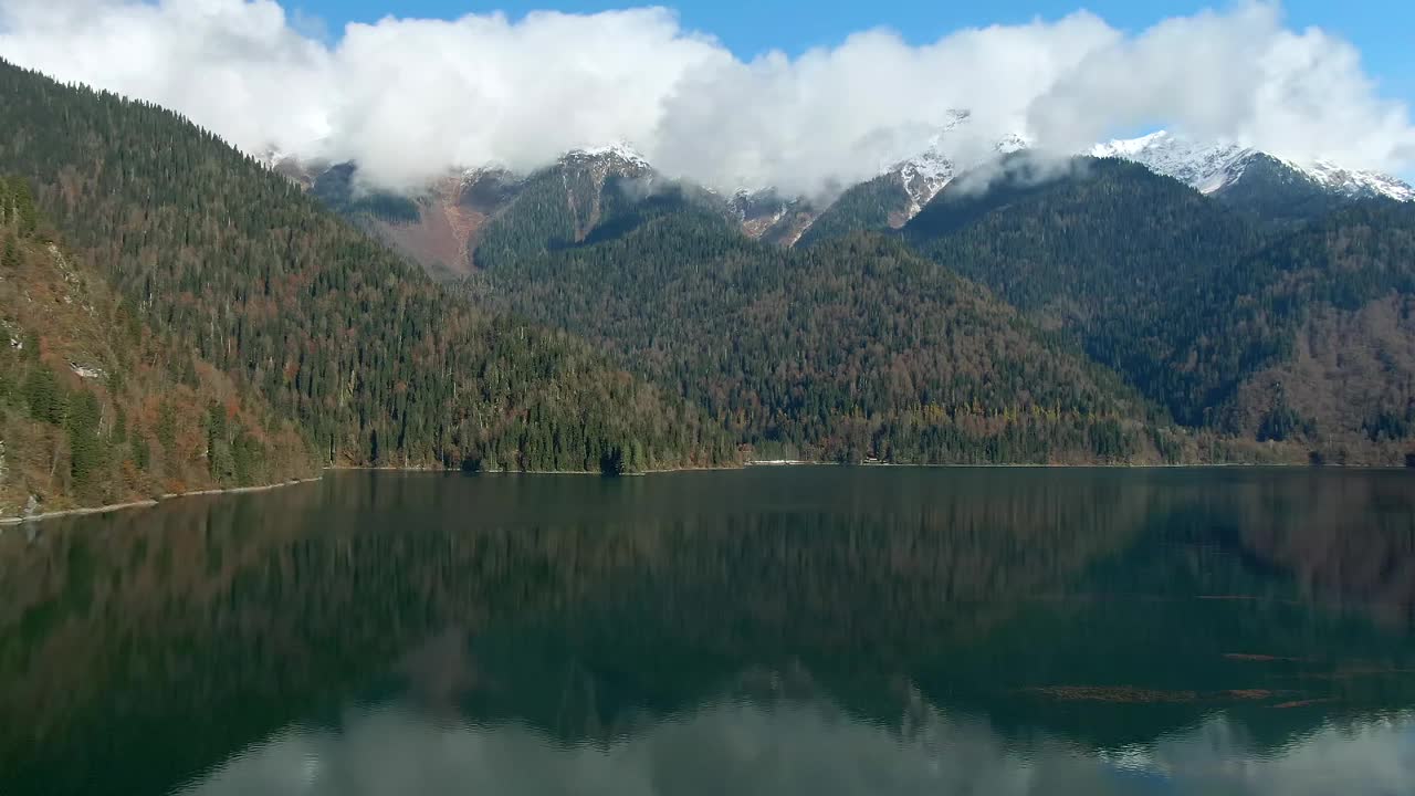 鸟瞰图美丽多彩的山景湖泊在森林中。山峰在平静的绿松石水中的倒影视频下载