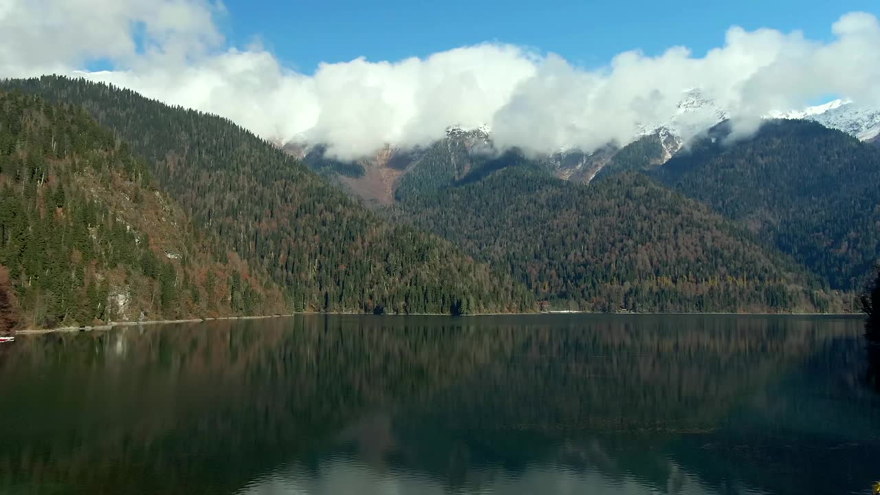 鸟瞰图美丽多彩的山景湖泊在森林中。山峰在平静的绿松石水中的倒影视频素材