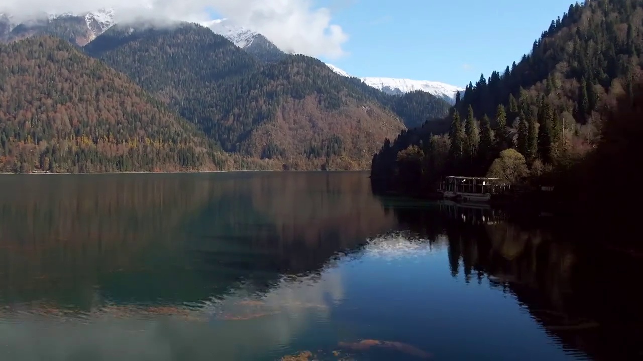 鸟瞰图美丽多彩的山景湖泊在森林中。山峰在平静的绿松石水中的倒影视频素材