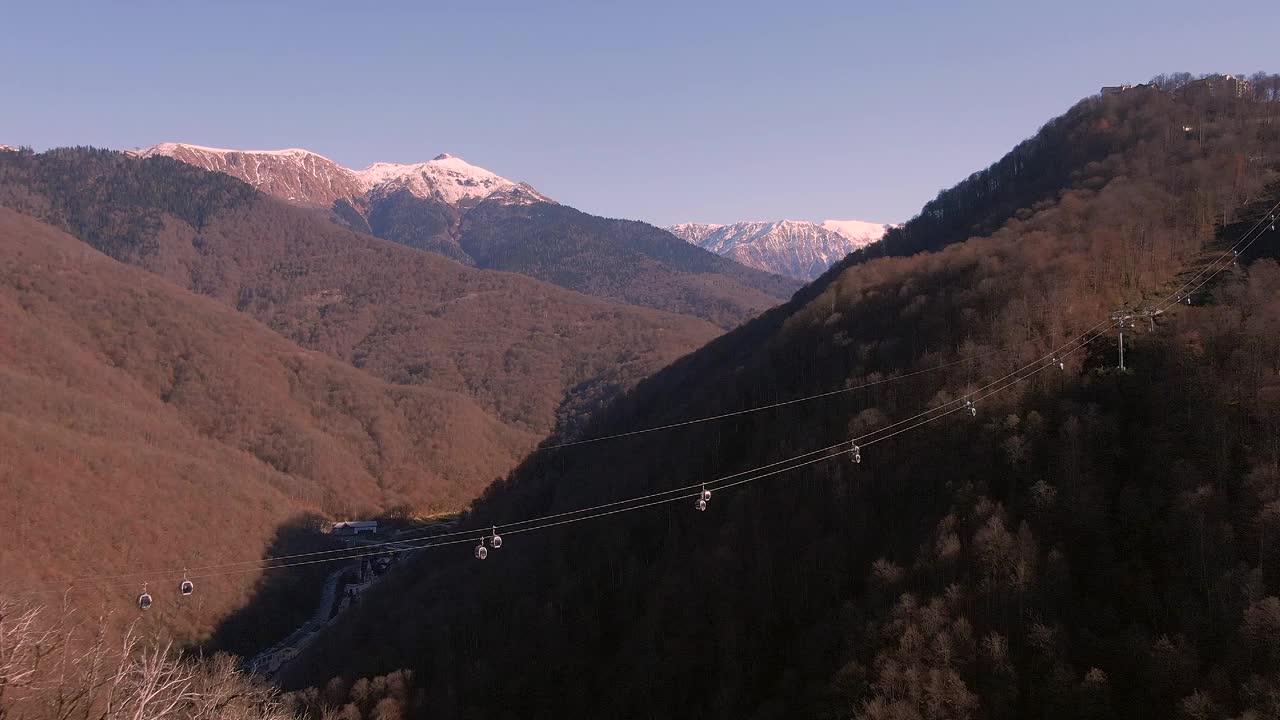 在缆车亭上方的峡谷中鸟瞰。鸟瞰山峰的全景视频下载