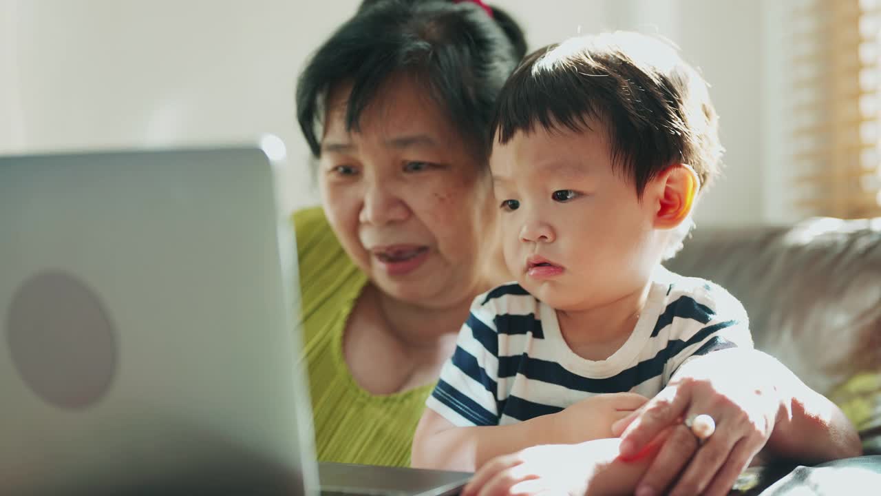 可爱的男孩和年长的女人一起在家里度过闲暇时光。视频素材