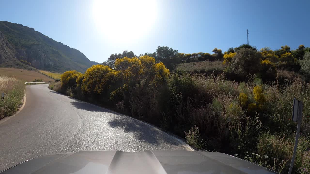 POV汽车行驶在笔直的两路旧沥青公路通过一座山在西班牙视频素材