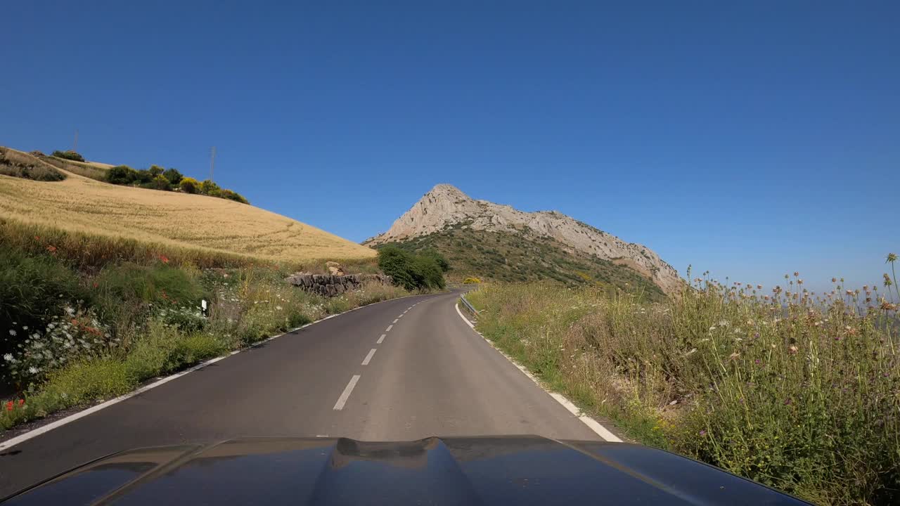 POV汽车行驶在笔直的两路旧沥青公路通过一座山在西班牙视频素材