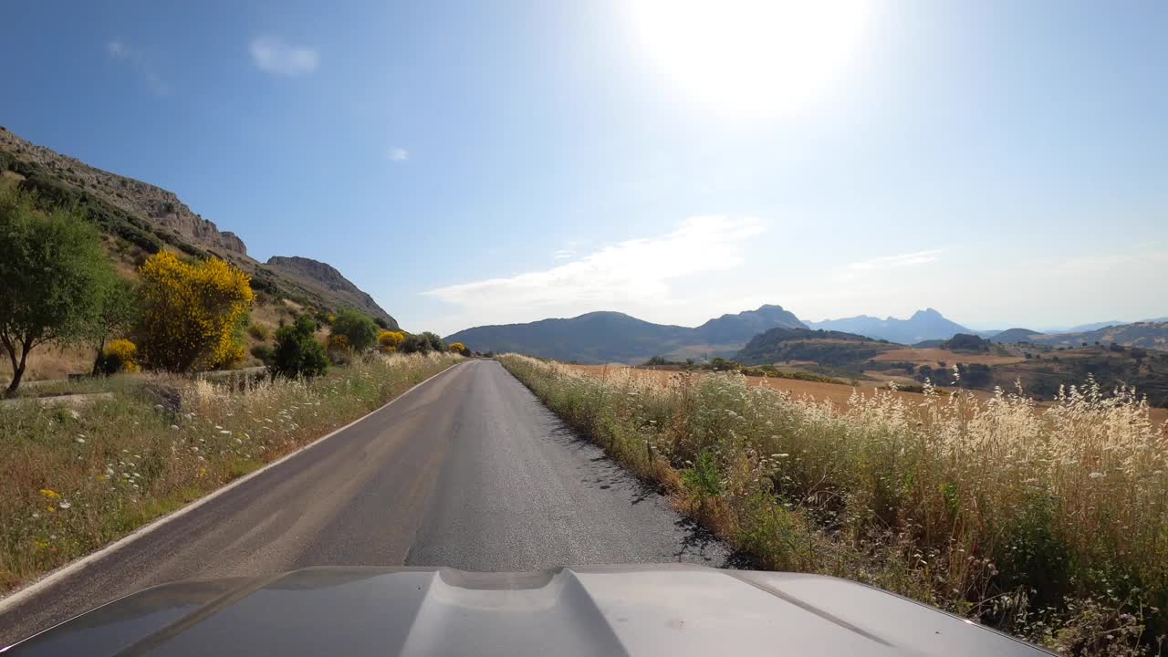 POV汽车行驶在笔直的两路旧沥青公路通过一座山在西班牙视频素材