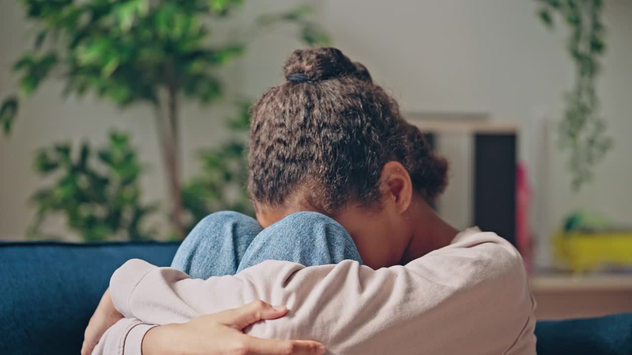 不开心的黑人女孩坐在沙发上，青少年沮丧的欺凌问题视频素材