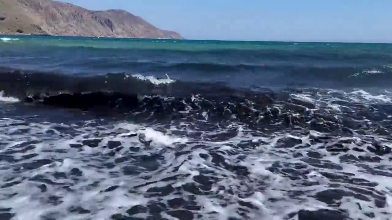 在克里特岛海浪，泡沫和溅起的海水的特写视图。视频素材