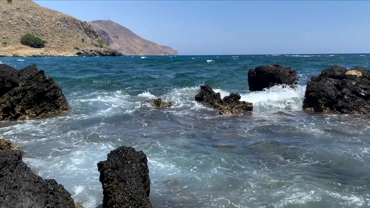 近距离观察波浪、泡沫和岩石间海水的溅起。视频素材