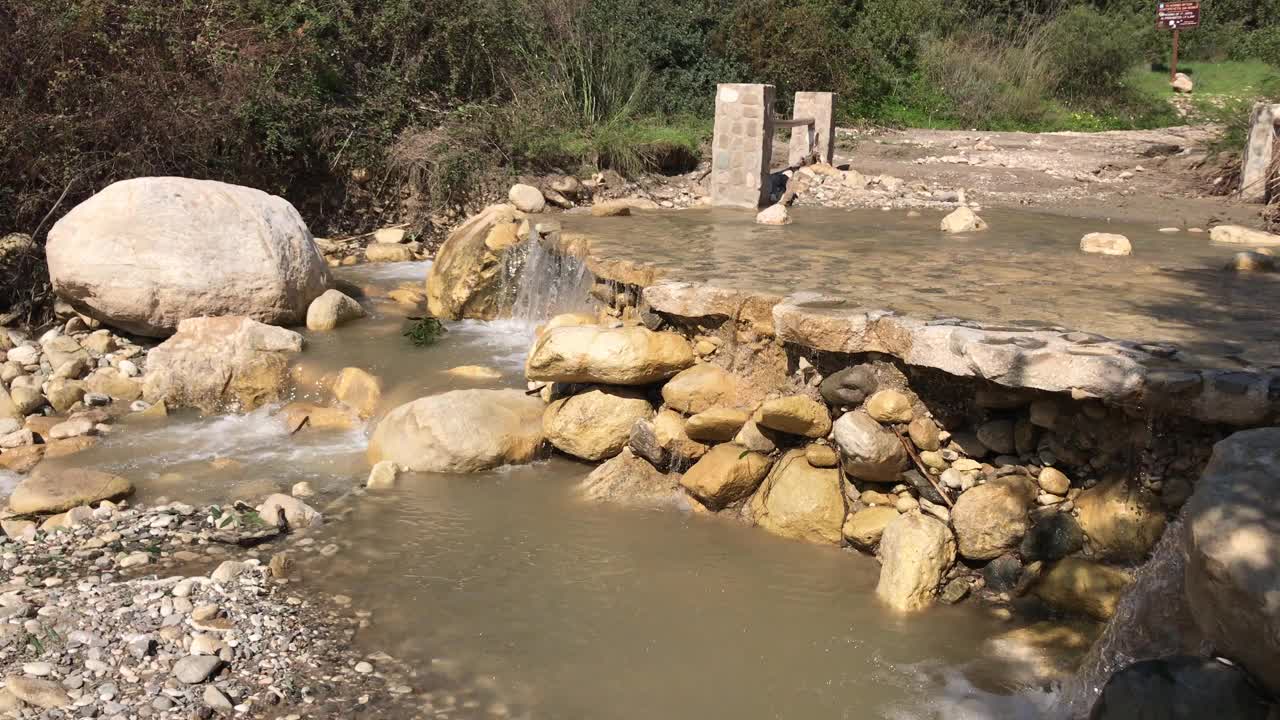 水从石头上流过。景观山涧瀑布流过岩石在夏日阳光灿烂的日子。4 k视频素材