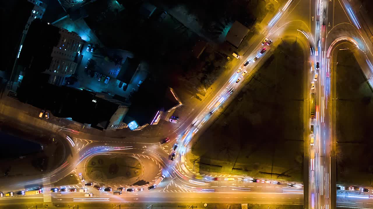 鸟瞰图的道路交叉口快速移动的繁忙的交通在夜间。城市交通的时间间隔。交通高峰期，汽车尾灯模糊不清视频素材