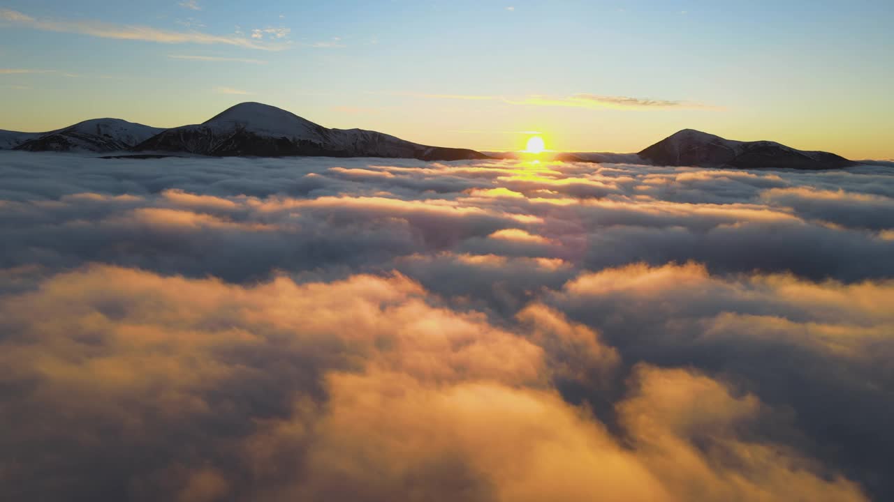 鸟瞰图中充满活力的日出在白色浓雾中，远处地平线上是喀尔巴阡山脉的黑色山峰视频素材