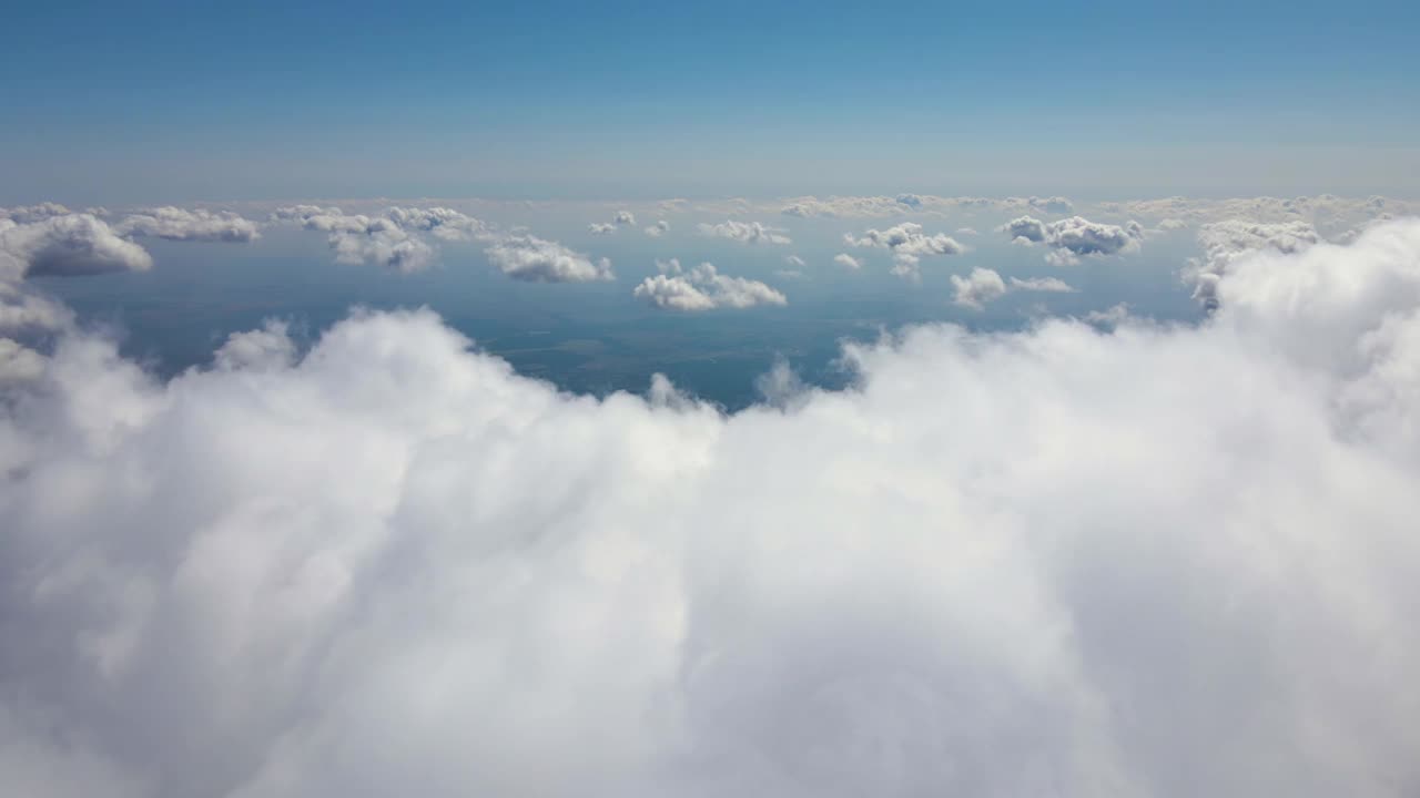 高空从飞机窗口俯瞰覆盖着白色蓬松积云的地面视频素材