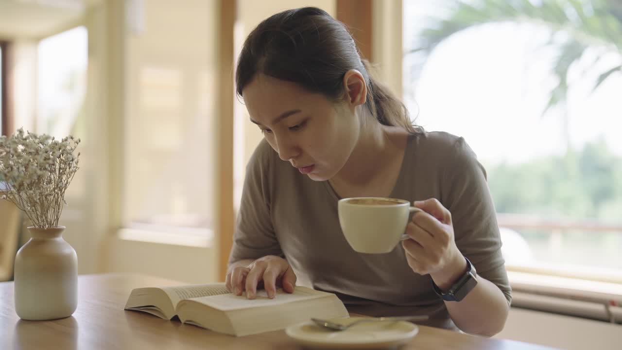 女人边喝咖啡边看书视频素材