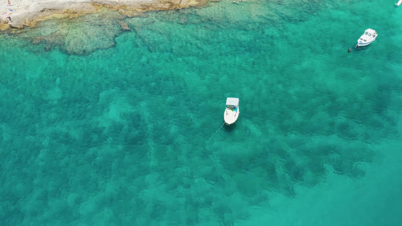 在海岸附近蔚蓝的海面上，放着床单和酒席的游艇视频素材