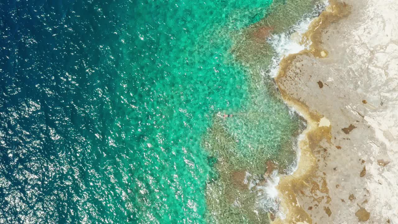 海边的景色，蔚蓝的海浪在岩石海滩上翻滚视频素材