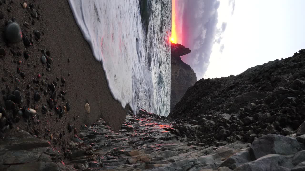 多彩的温暖的日落在海上和火山玄武岩，就像在冰岛。海浪冲击着岩石，在温暖的落日的照耀下，浪花飞溅，浪花翻滚。永恒的自然之美视频素材