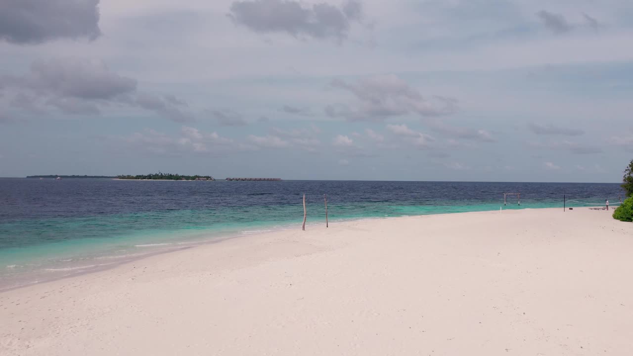 无人机飞越马尔代夫的热带海滩、天际线和多云天气视频素材