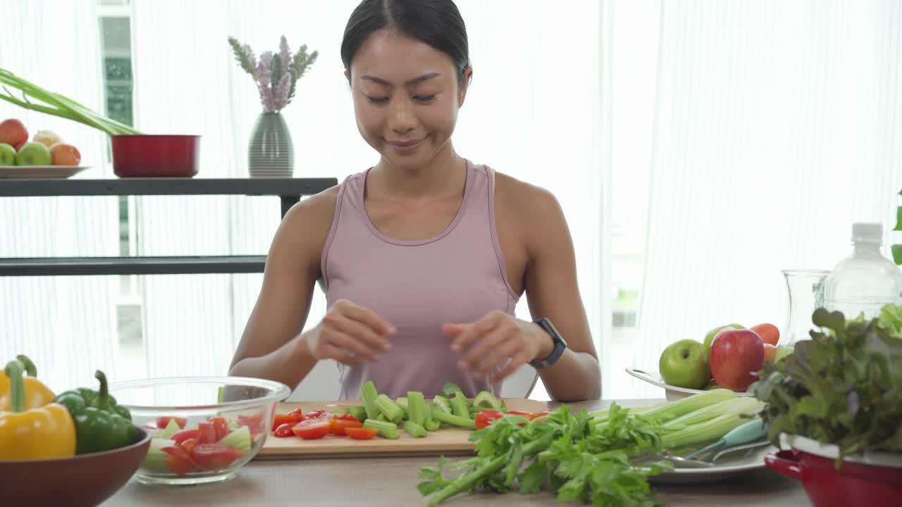 亚洲运动女孩准备沙拉在厨房健康食品的概念视频素材