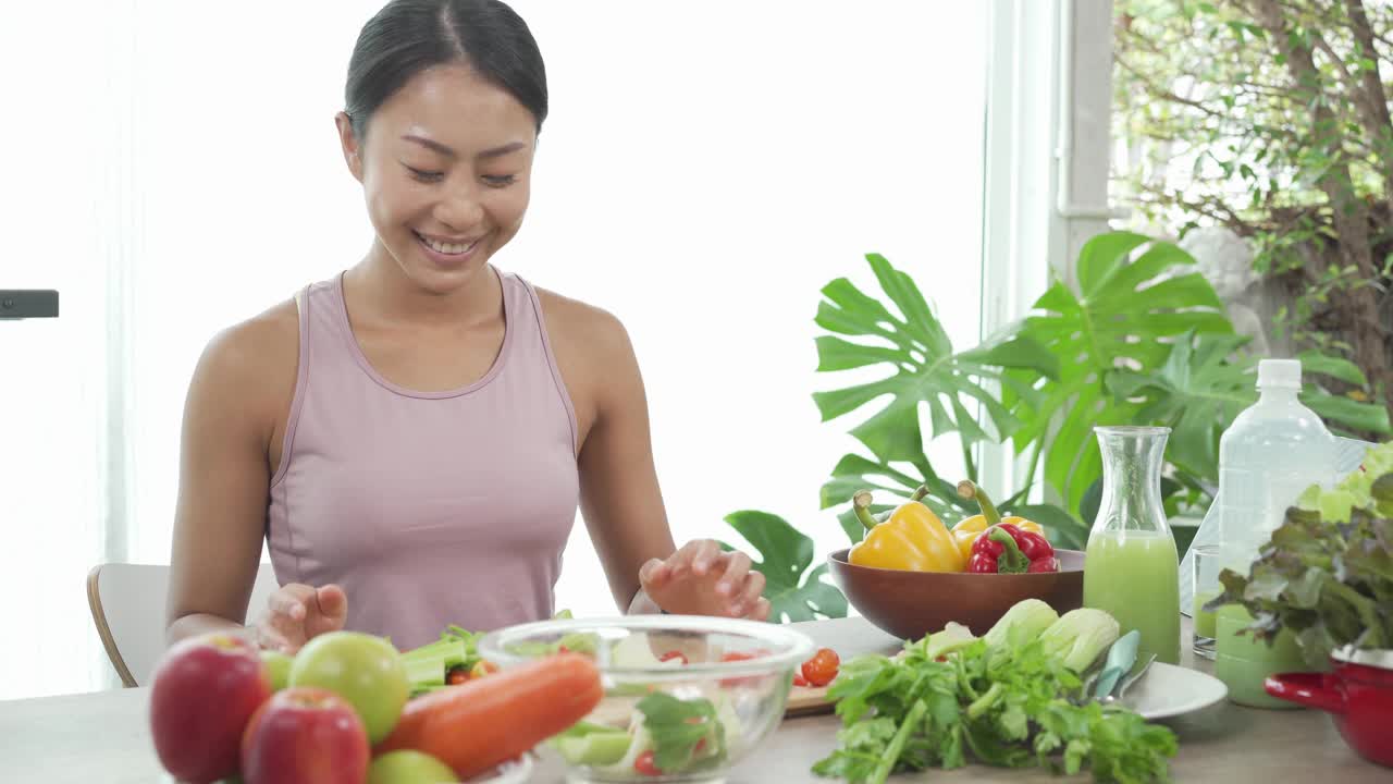 亚洲运动女孩准备沙拉在厨房健康食品的概念视频素材