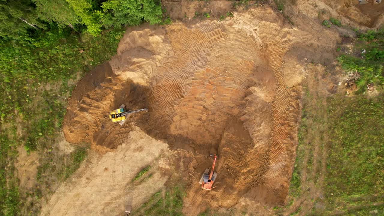 挖掘机在施工现场挖掘地面。某多层建筑基坑工程。运土的重型设备。视频素材