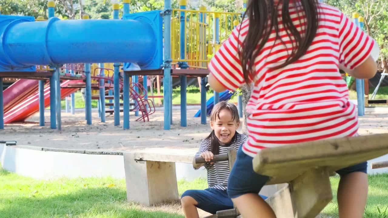 活泼的小妹妹们在户外操场上玩跷跷板。快乐的童女们在孩子们的操场上笑着、笑着。玩耍在孩童时期就是学习。视频素材