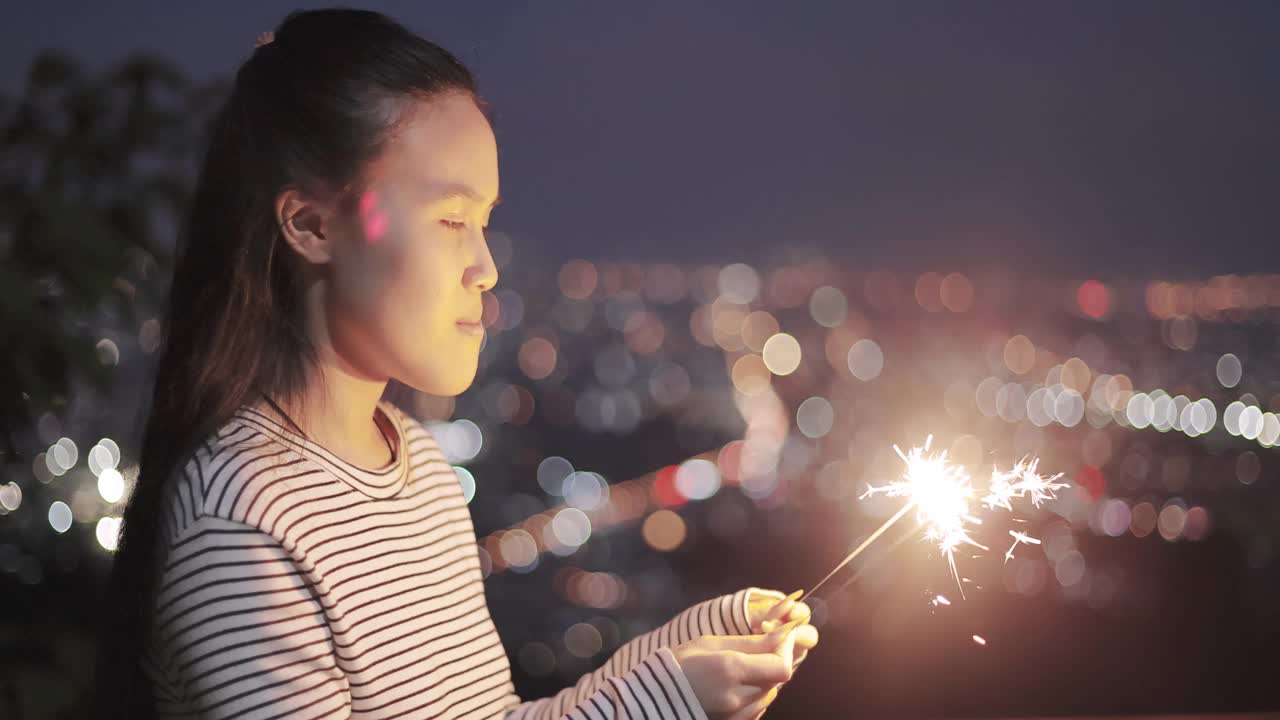 快乐的亚洲女孩玩烟花视频素材