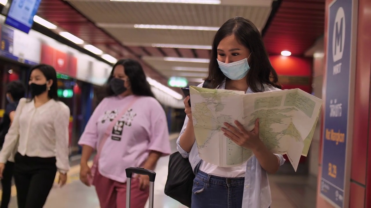 亚洲旅行在地铁站看手机视频素材