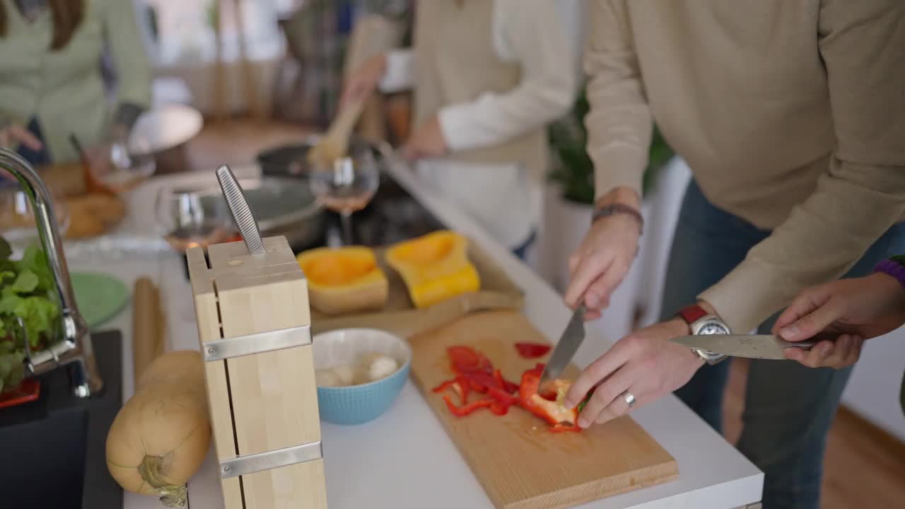 剁红柿子椒的男人和朋友在家里做午饭视频素材