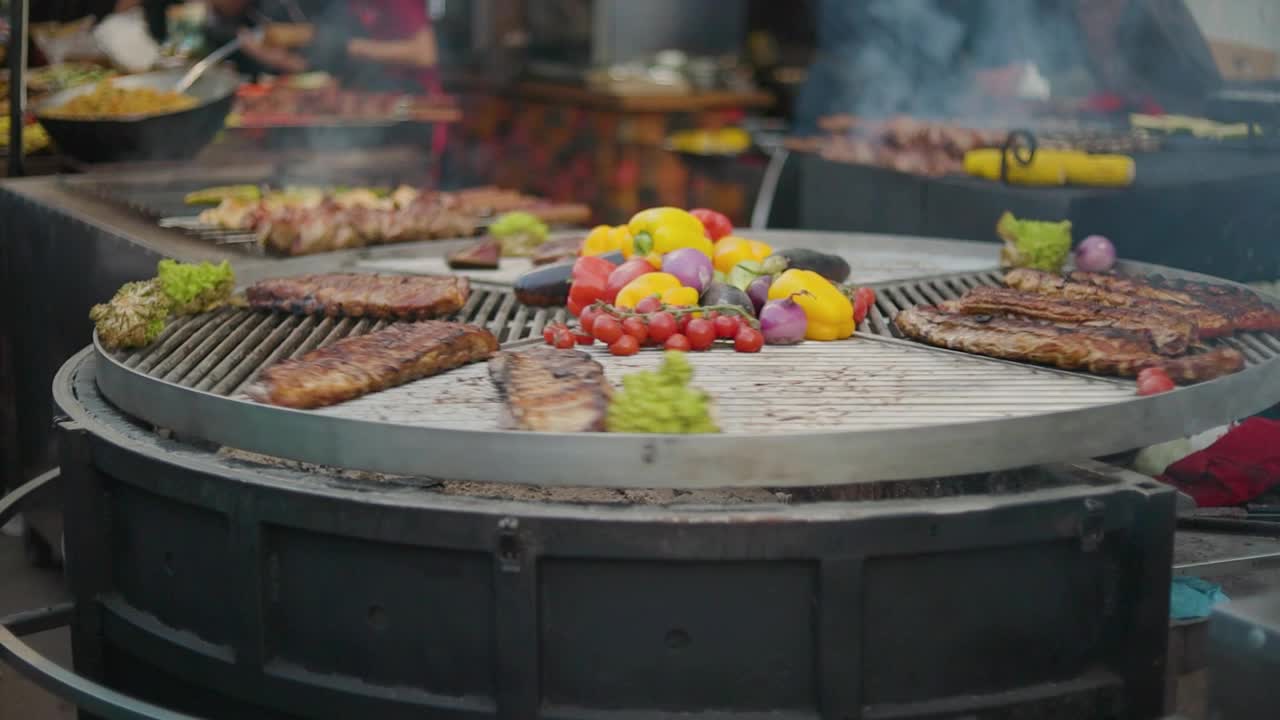 旋转烤肉上的肉和蔬菜。旋转烤架与烤蔬菜和肉类。街头食品市场视频素材