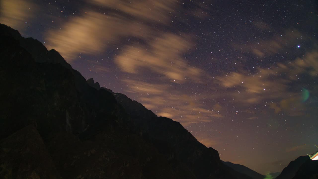 时光流逝，虎跳峡。陡峭的山脉有星星和银河。在夜晚移动的云。视频素材