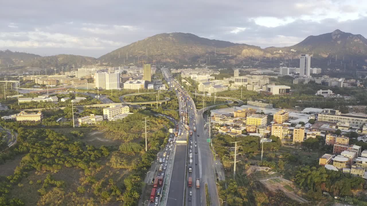 在夕阳下，拥挤的交通流在城市建筑和主干道上视频下载