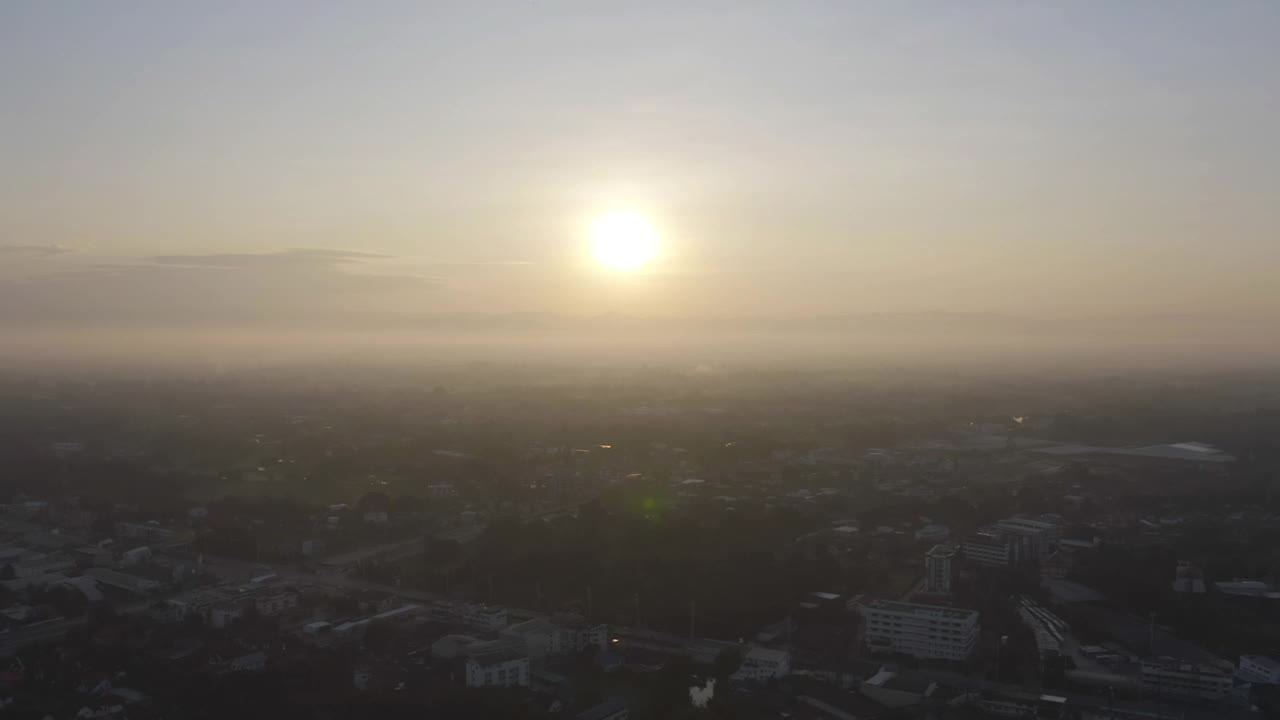 空中俯瞰清迈市区天际线与雾和太阳，泰国。亚洲城市的金融区和商业中心。日落时的摩天大楼和高层建筑。视频素材