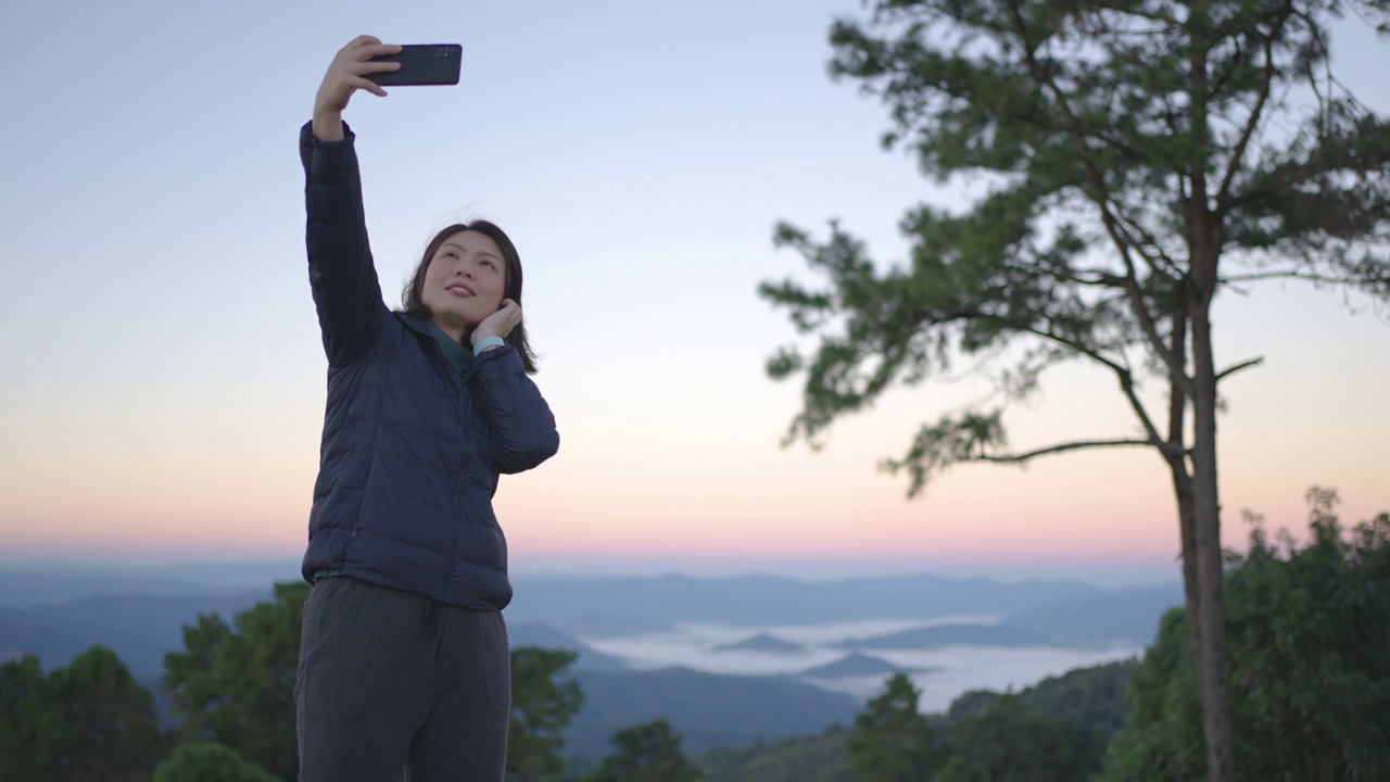 女旅行者在山区自然国家公园用智能手机拍风景照片视频素材