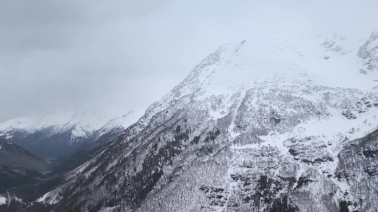 缓慢的运动。山顶积雪覆盖的山坡和山谷的俯视图视频素材