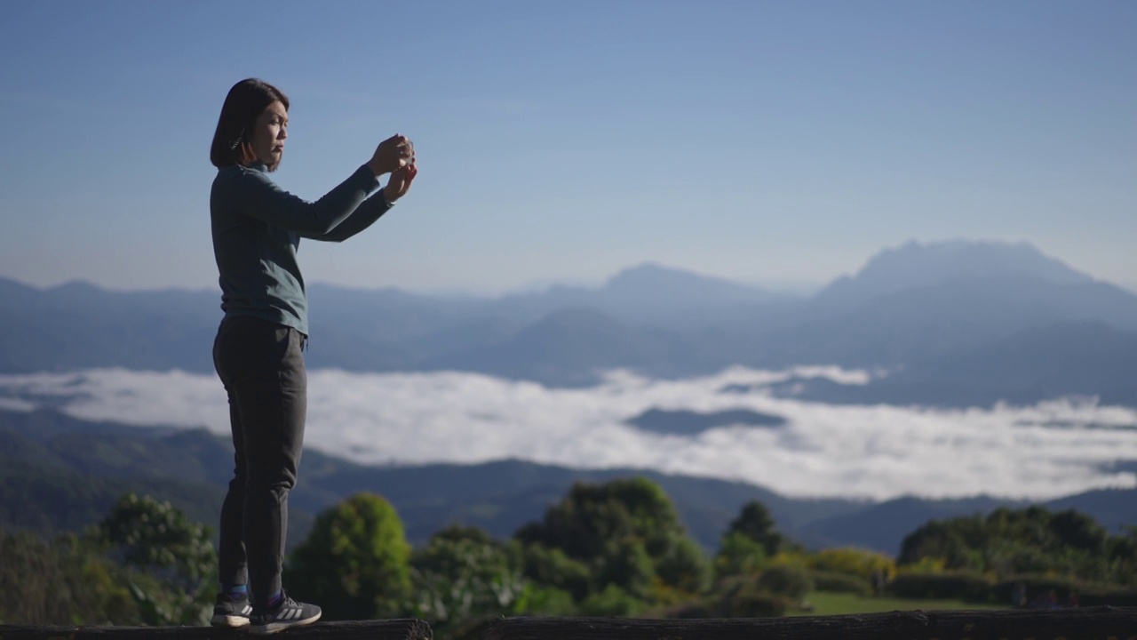 女旅行者在山区自然国家公园用智能手机拍风景照片视频素材