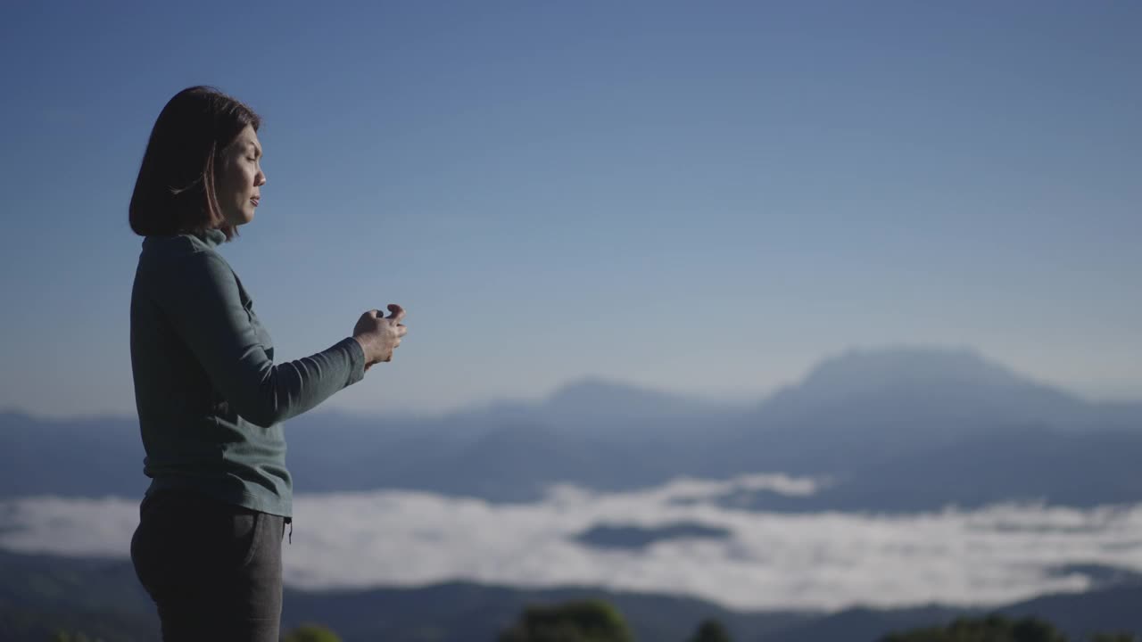 女旅行者在山区自然国家公园用智能手机拍风景照片视频素材