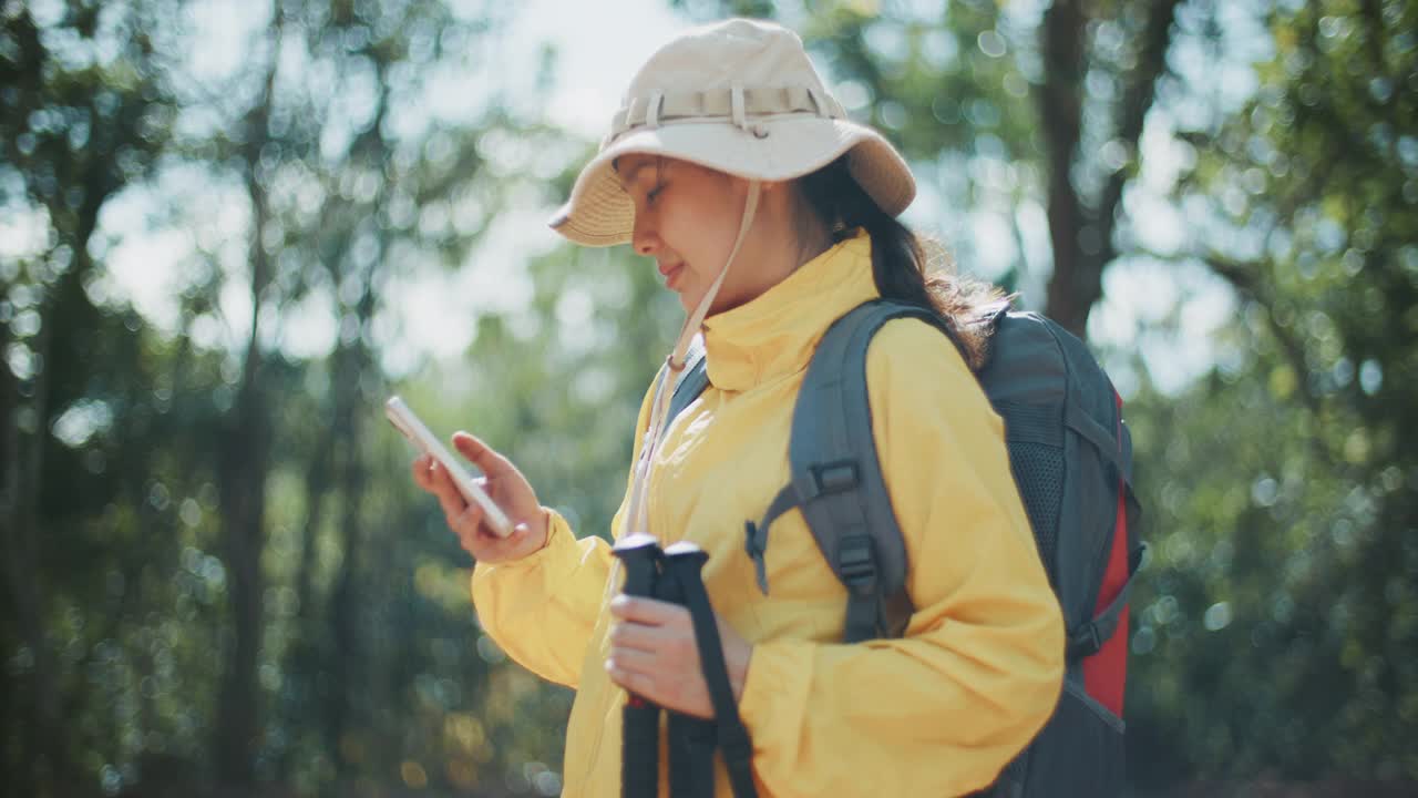 一名女子在徒步旅行时使用手机视频素材