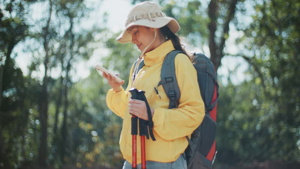 一名女子在徒步旅行时使用手机视频素材