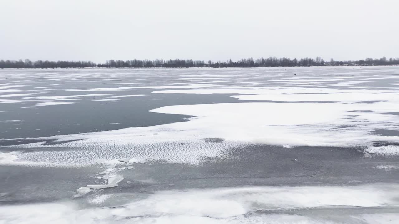 雪河冬季景观。河边结冰的冰雪。春天融化了水面上的冰。视频素材