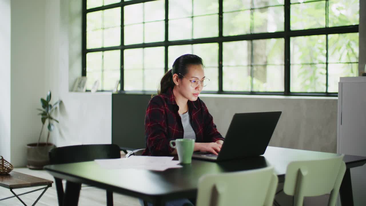 亚洲女性使用笔记本电脑在家里工作视频素材