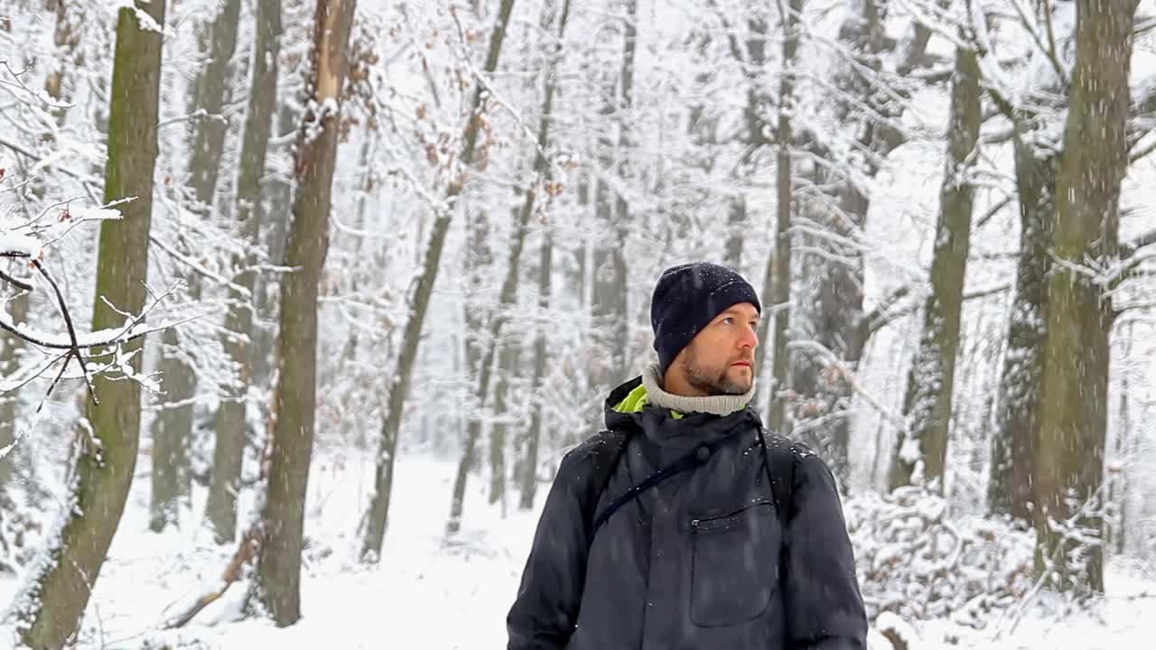 肖像年轻的高加索人向上看，进入相机与模糊的雪林捷克景观视频素材