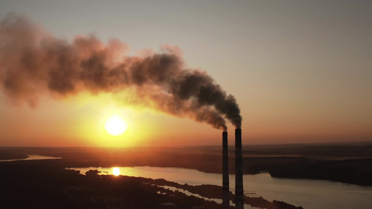 日落时工厂污染环境。有毒的企业烟囱管映衬着夜空背景释放出黑烟。在自然界中产生有害物质的烟斗。视频素材