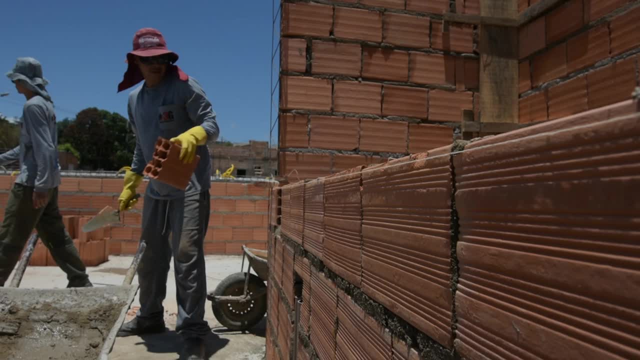 年轻的成年人建造砖墙的房子视频素材