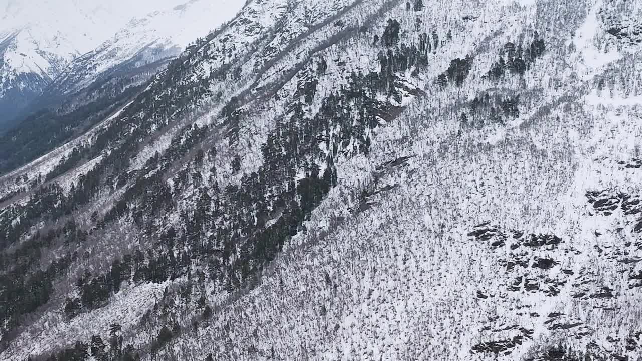 缓慢的运动。山顶积雪覆盖的山坡和山谷的俯视图视频素材