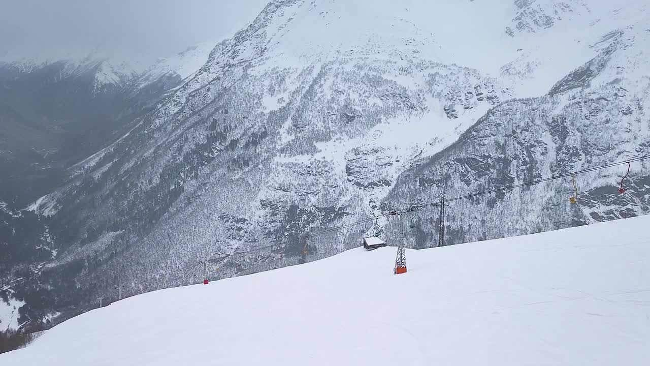 缓慢的运动。无人驾驶飞机射击。山顶度假村滑雪坡道和缆车的俯视图视频下载